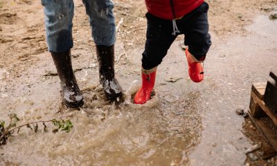 Person in Red Jacket and Blue Denim Jeans Wearing Red Boots Standing on Water