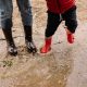 Person in Red Jacket and Blue Denim Jeans Wearing Red Boots Standing on Water