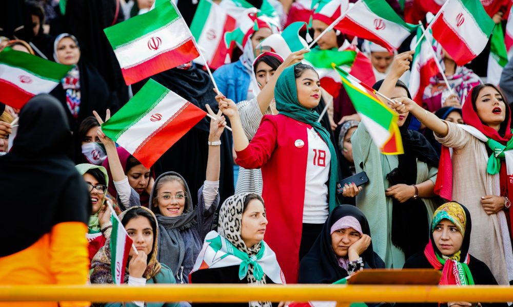 women wearing hijab holding iran flags