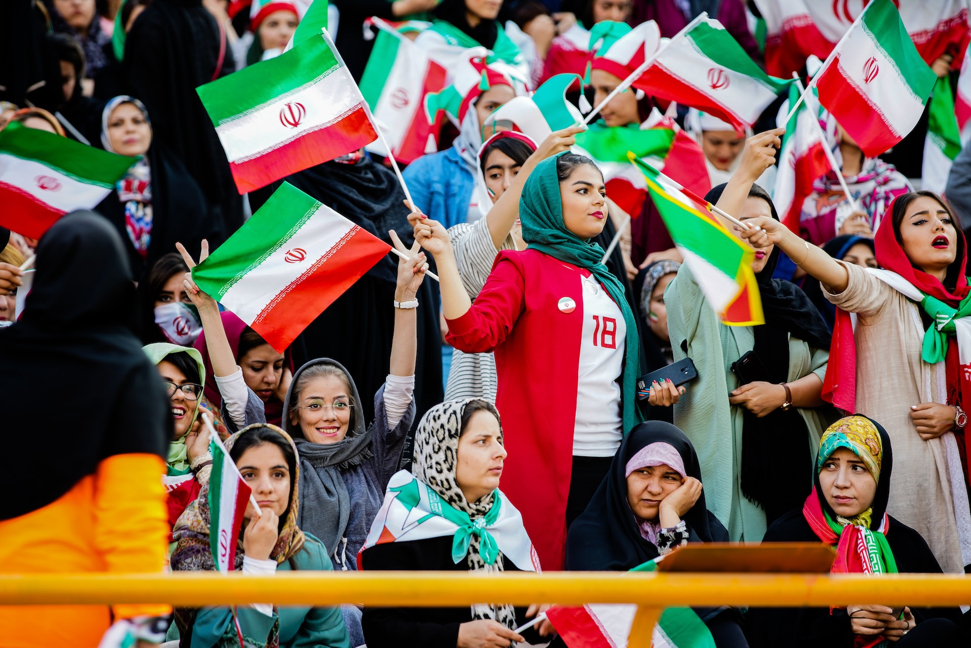 women wearing hijab holding iran flags