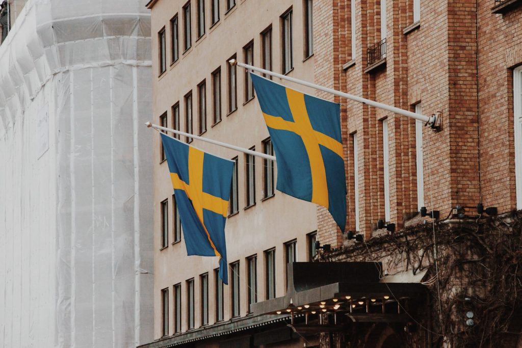 two sweden flag raised on window building
