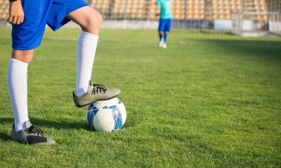 A Person Stepping on the Ball while Wearing Cleats