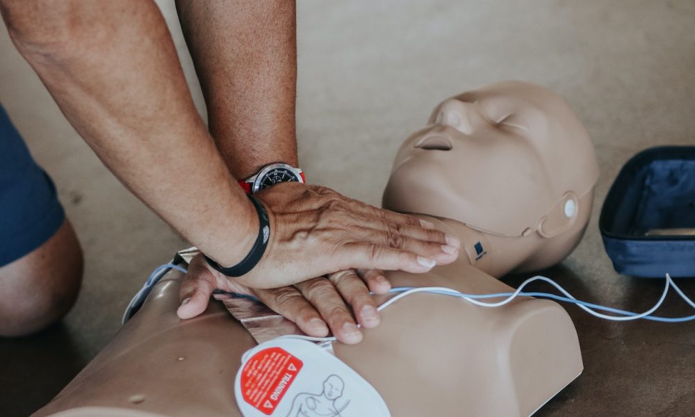 man execurting CPR on mannequin