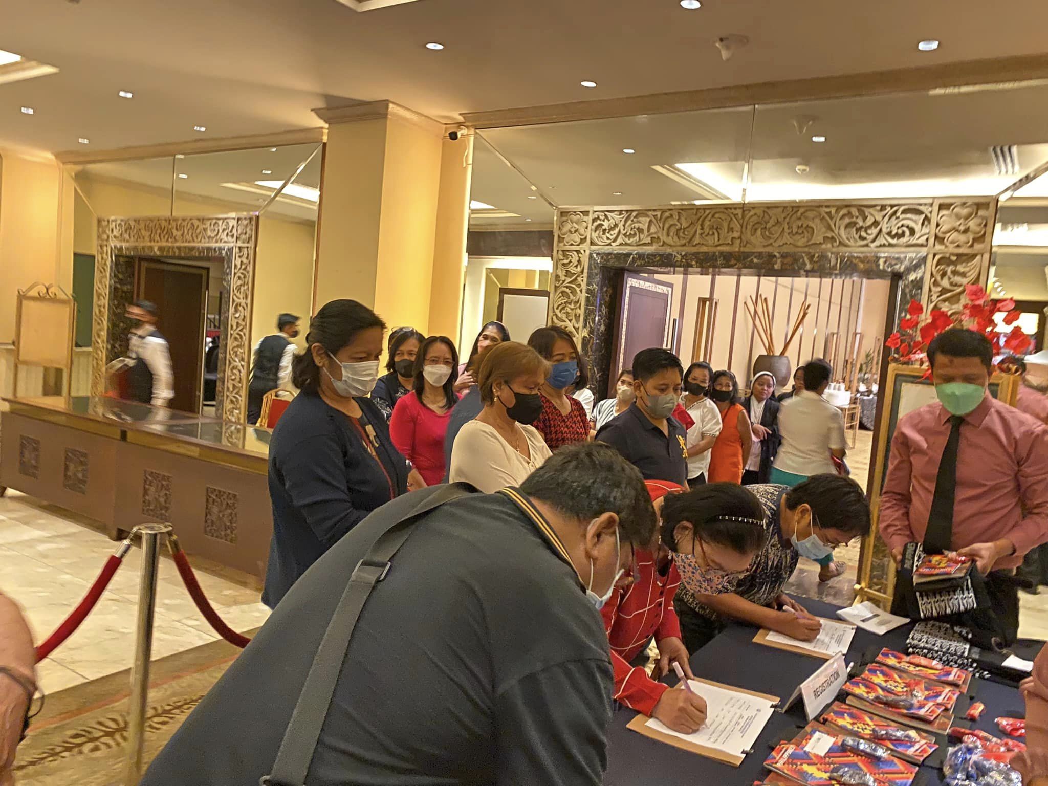 Migrant workers and their families register to attend the National Forum on Migration
