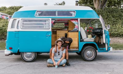 A Happy Couple Sitting by the Side of a Campervan