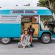 A Happy Couple Sitting by the Side of a Campervan