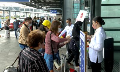 Airport security personnel check the documents of passengers