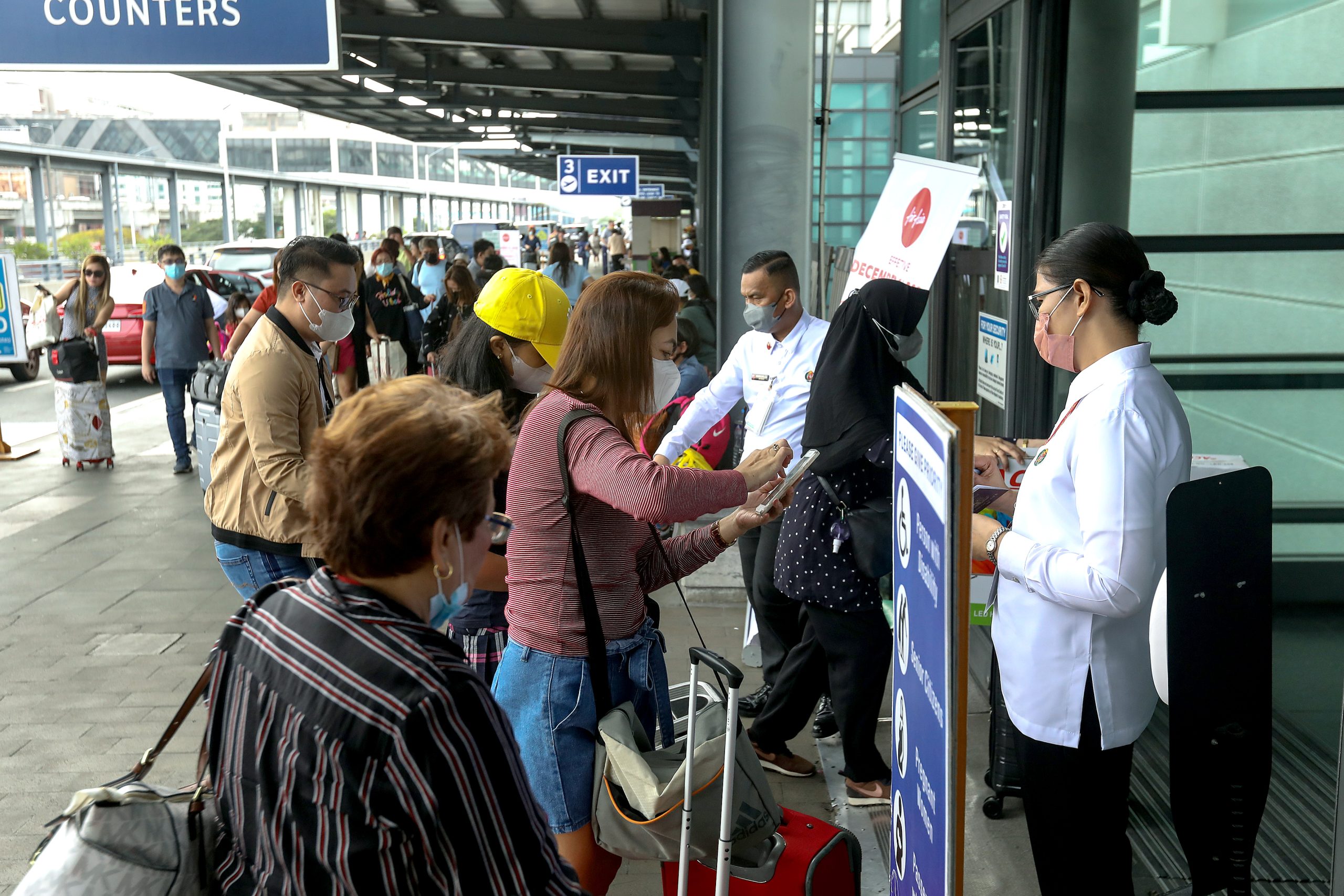Airport security personnel check the documents of passengers