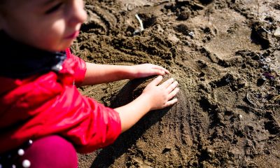 Kid playing on wet sandy beach