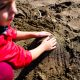 Kid playing on wet sandy beach