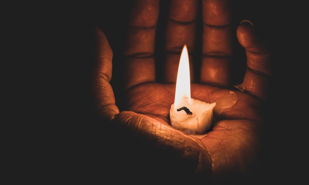 Lit candle on a hand