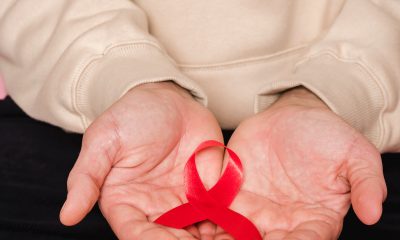Red Ribbon On Person's hands