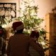 Woman and a girl sitting in front of a Christmas tree