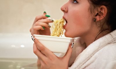 woman eating noodles on bowl