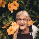 old woman laughing with flowers around