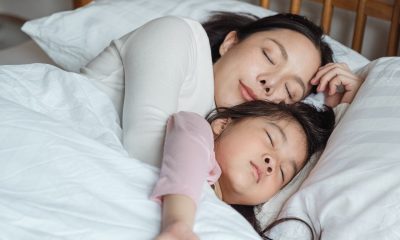 mom and daughter sleeping on bed