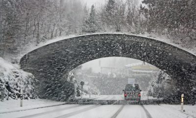 white car passing through tunnel amid winter storm