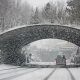white car passing through tunnel amid winter storm