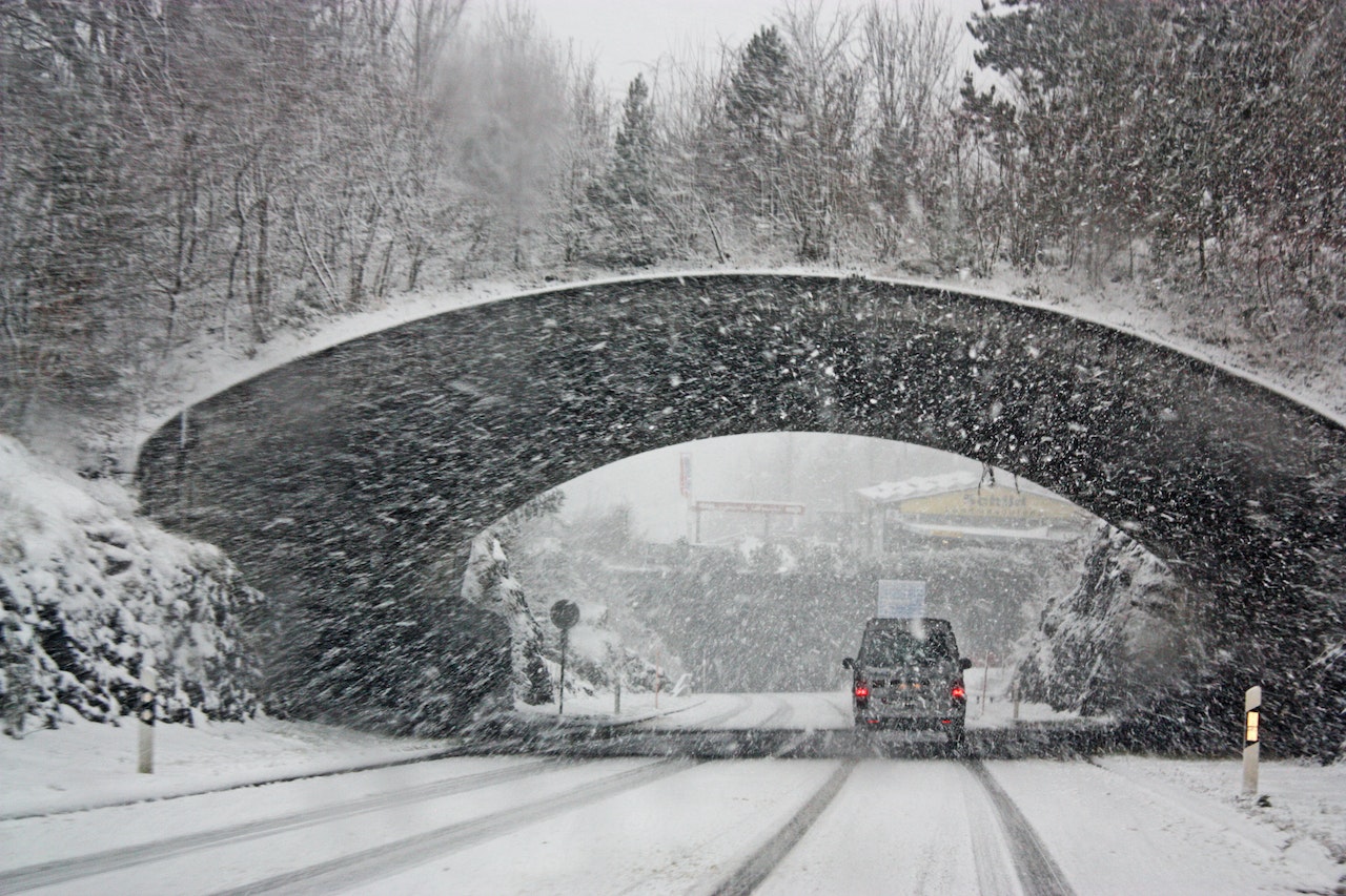 white car passing through tunnel amid winter storm