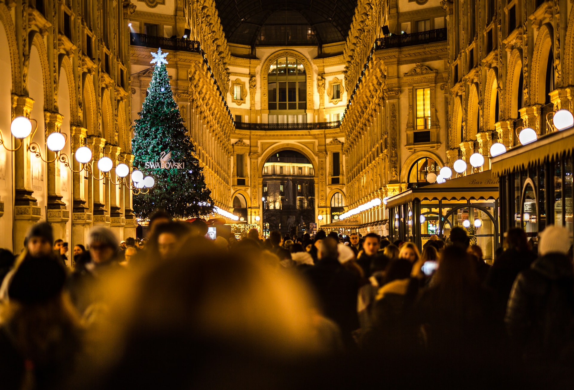 people walking around christmas tree in milan