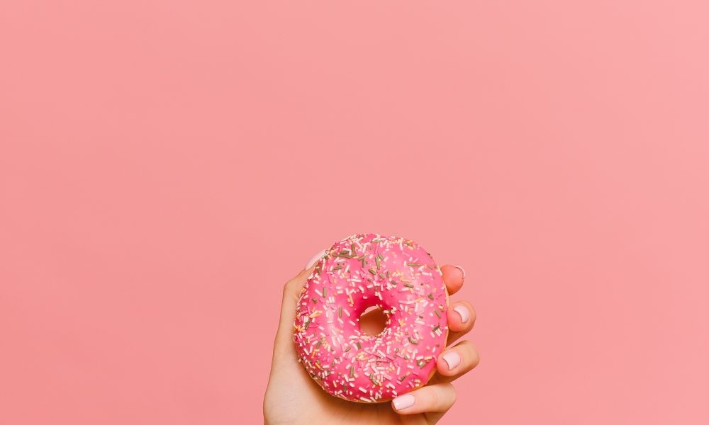 A Person Holding Pink Donut