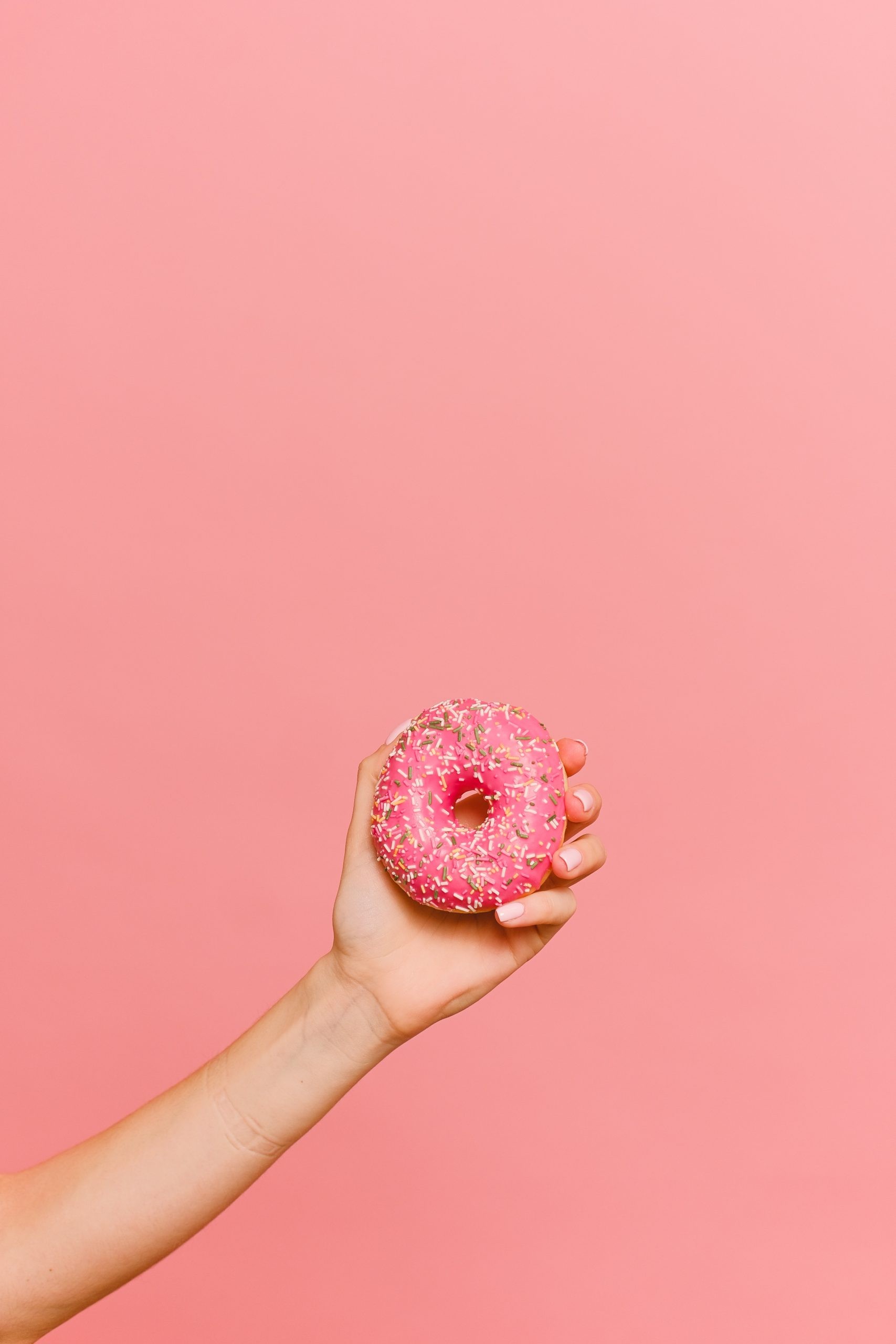 A Person Holding Pink Donut