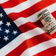 American flag with rolled dollar bills