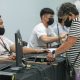 An elderly woman places her thumb on a scanning device for her biometric