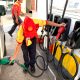 An employee fills up a car's fuel tank at a gasoline station