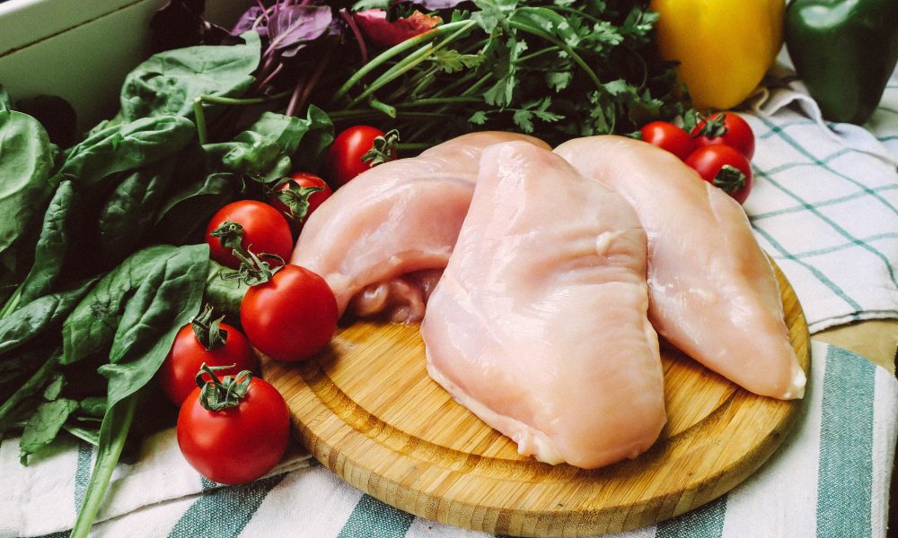 Chicken Meat on the Wooden Chopping Board Beside Vegetables