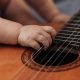 Close-Up Shot of a Baby Playing Acoustic Guitar