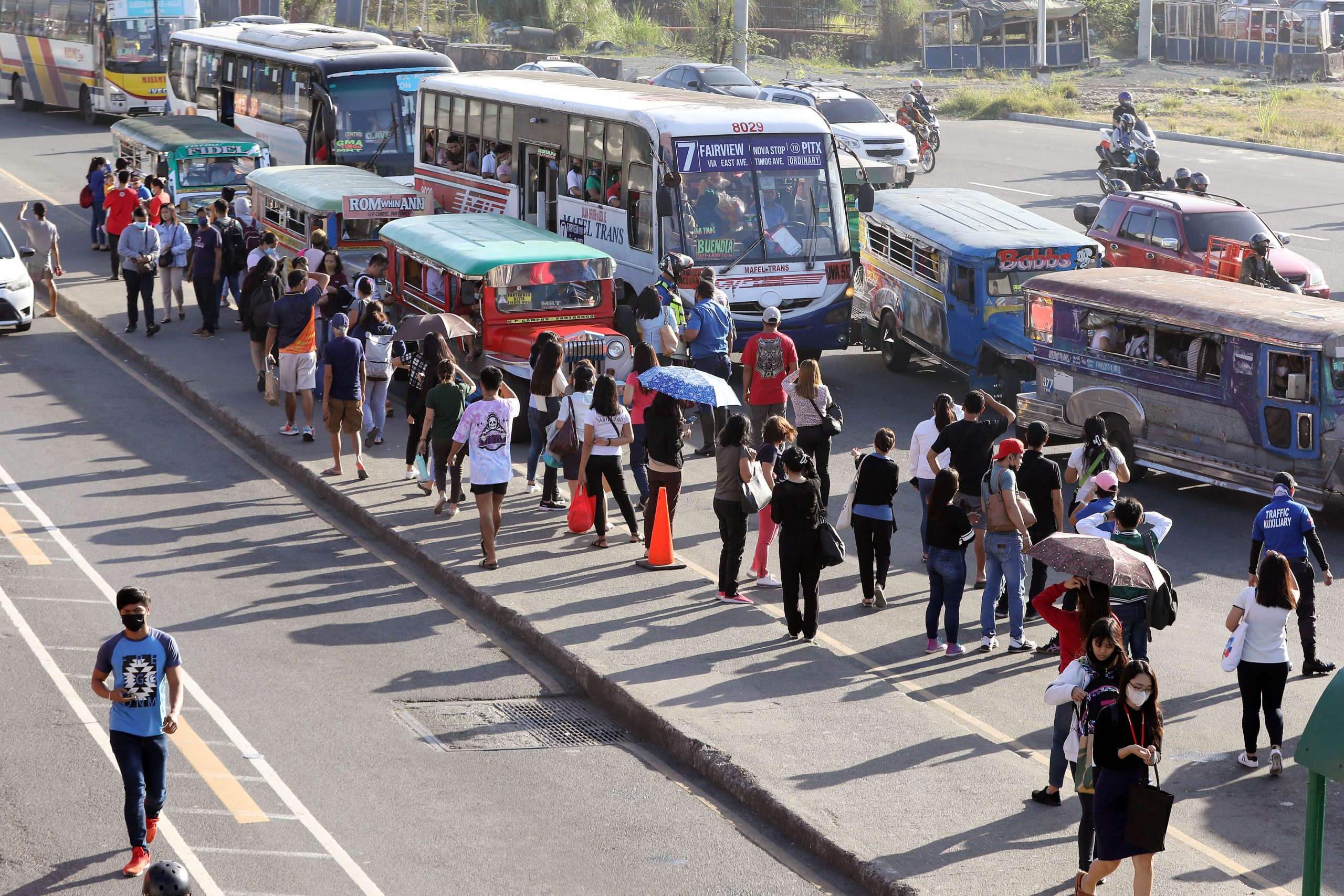 Passengers queue up for bus and jeepney rides