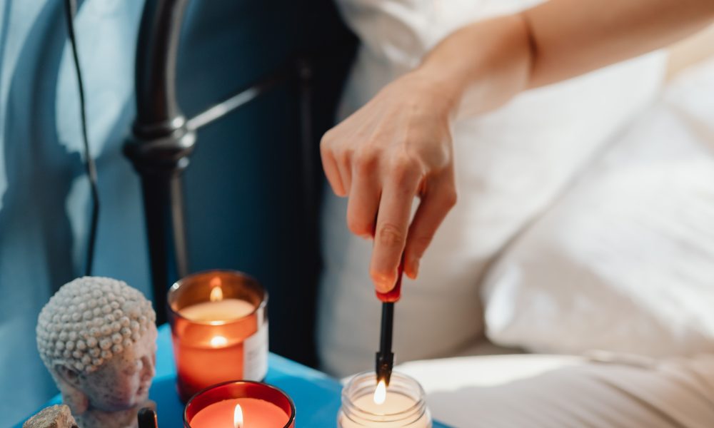 Person Lighting a Candle Using a Lighter