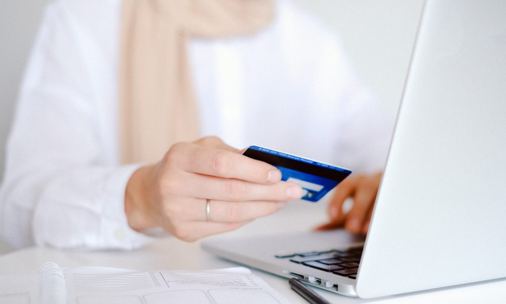 Person in White Long Sleeve Shirt Holding Credit Card