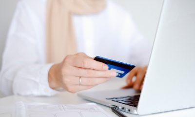 Person in White Long Sleeve Shirt Holding Credit Card