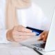 Person in White Long Sleeve Shirt Holding Credit Card