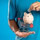 Photo of a Person with a Piggy Bank and a Shopping Cart