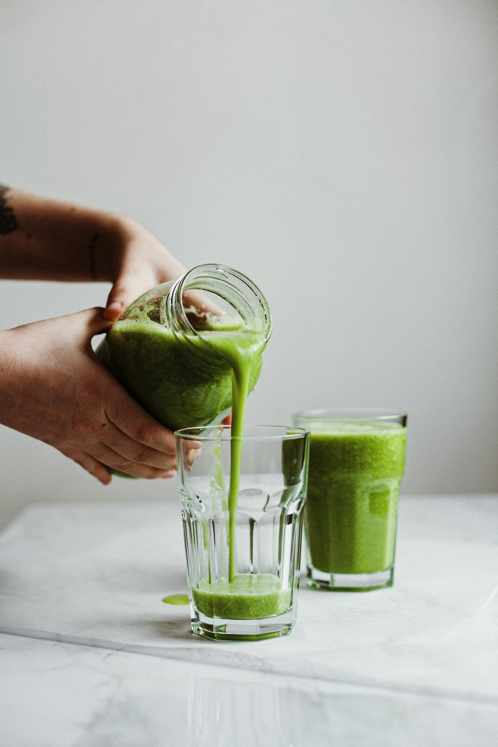 pouring green drink on glass