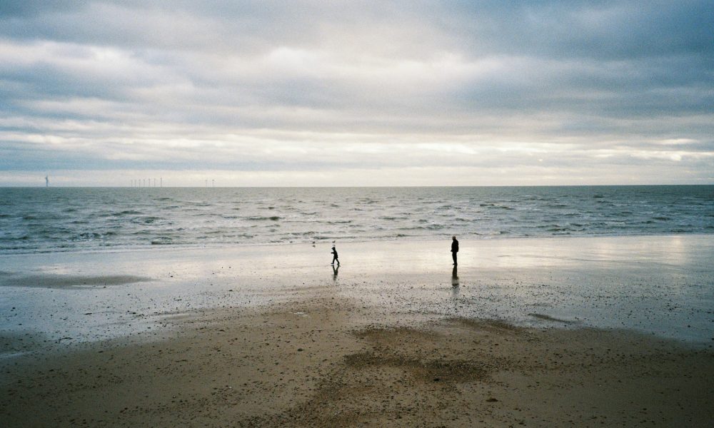 2 people walking on beach
