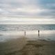 2 people walking on beach