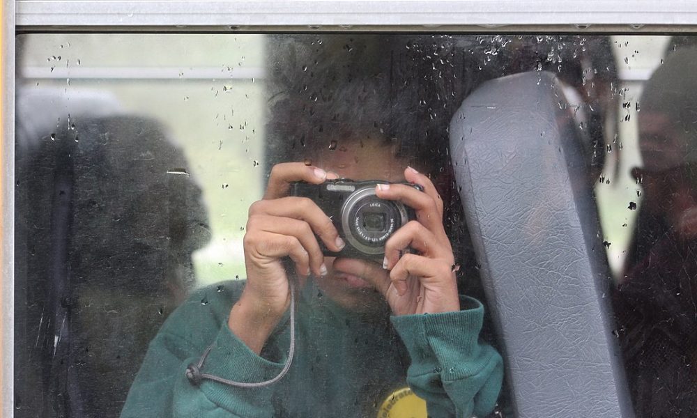 student holding an old digital camera