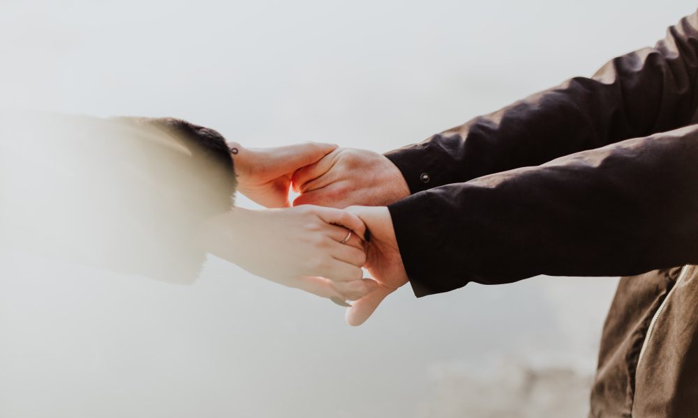 Two persons holding hands