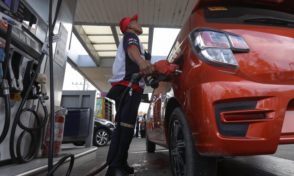 gasoline station employee fills up a vehicle