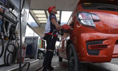 gasoline station employee fills up a vehicle
