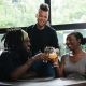 Three Persons Cheers With Clear Glasses Filled With Liquid Beverages Near Window