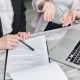 person pointing to paper with pen