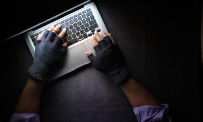 hands with gloves typing on keyboard