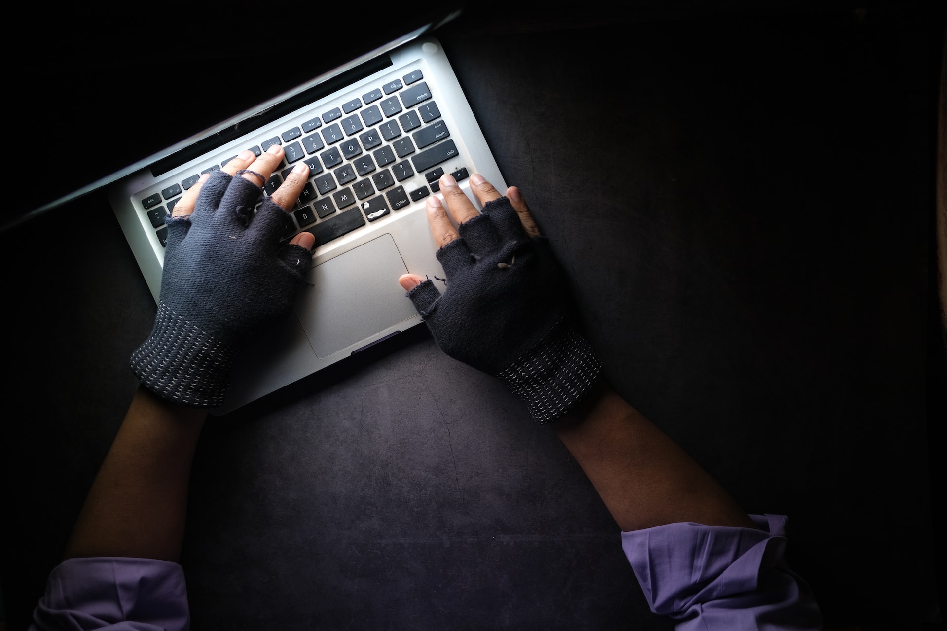 hands with gloves typing on keyboard
