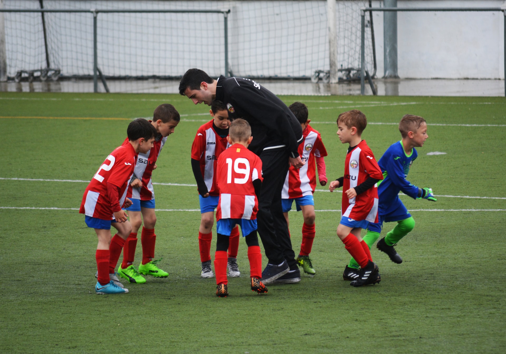 kids playing football with coach