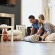 couple rolling out carpet on floor